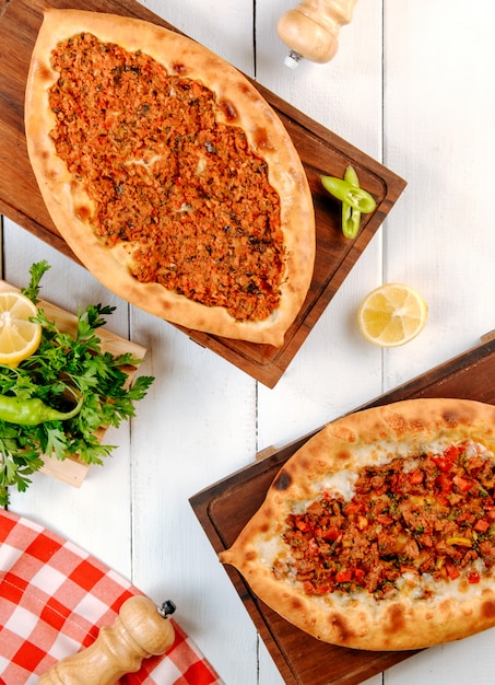 Meat pide with lemon and green on the table