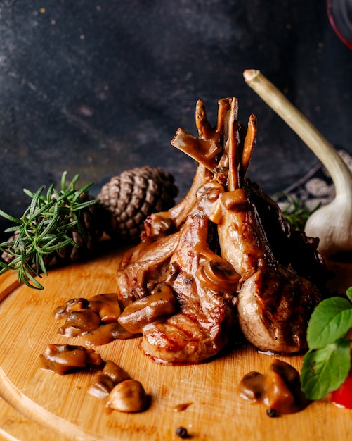 Куски мяса вместе со свежими цветными овощами на коричневой деревянной поверхности и серой поверхности