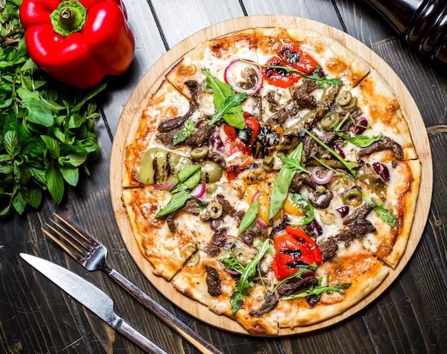 Meat pizza bell pepper basil arugula tomato cheese onion top view