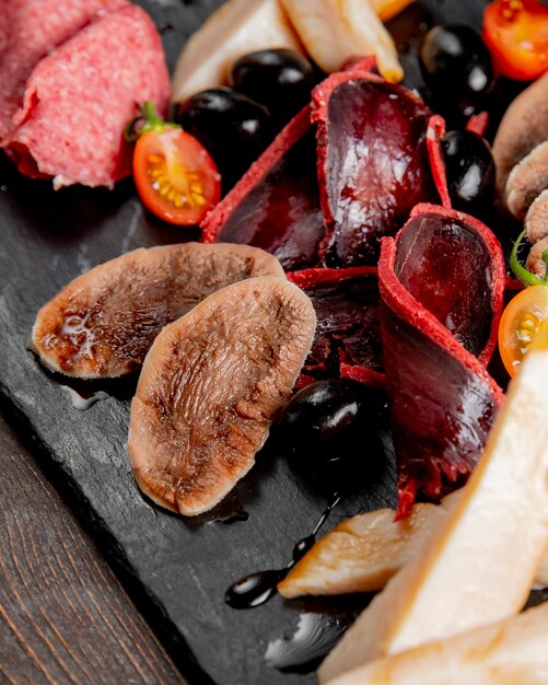 Meat plate with olives and tomatoes
