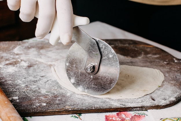 茶色の木製の素朴な机の上で生地を作る過程で肉クッタブ