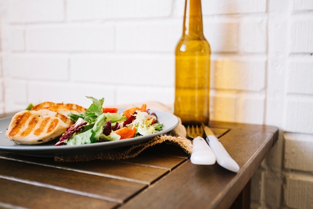 Foto gratuita carne e insalata vicino a forchetta e coltello