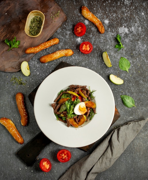 Foto gratuita insalata di carne con patate, uova ed erbe