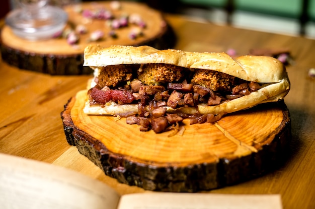 Meat sandwich on wooden board side view