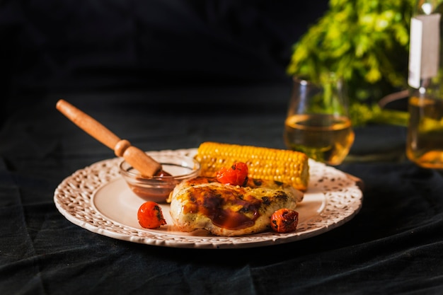 Meat served with cherry tomato and corn