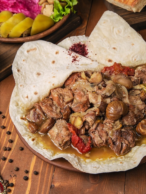 Meat stew, turshu govurma with onions, and chestnuts served in lavash   
