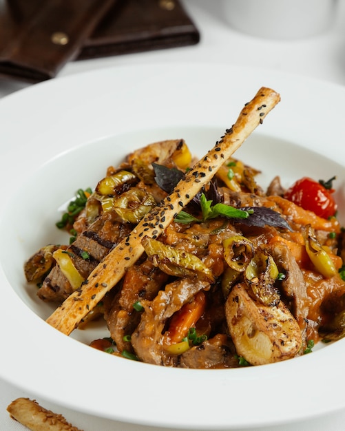 Meat stew with tomato,herbs and galetta stick.