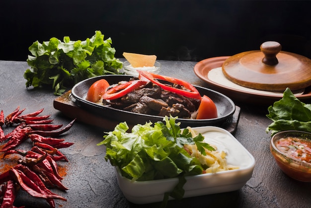 Meat, vegetables and appetizer on wooden table