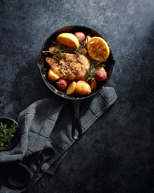 Meat and vegetables in a black pot on a black surface