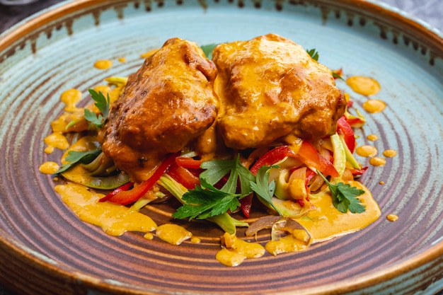 Meatballs dish topped with curry sauce served with sauteed vegetables