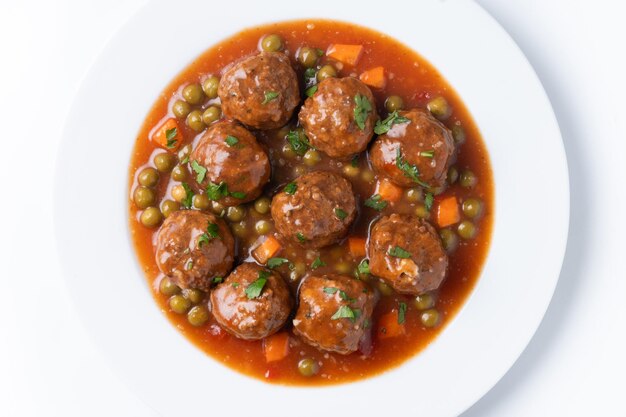 Meatballs green peas and carrot with tomato sauce isolated on white background