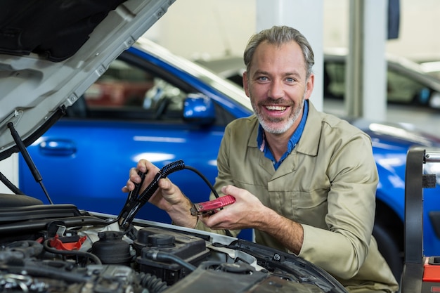 Mechanic attaching jumper cables to car battery