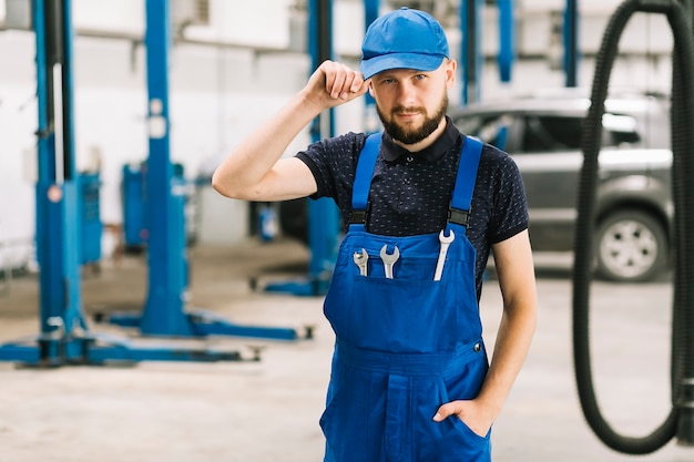 Foto gratuita meccanico in cappuccio all'officina dell'automobile