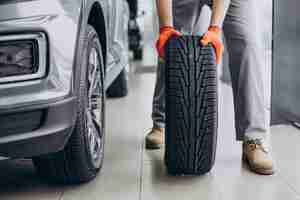 Foto gratuita meccanico che cambia le gomme in un servizio di auto