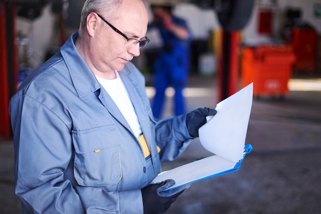 Free photo mechanic checking a car report