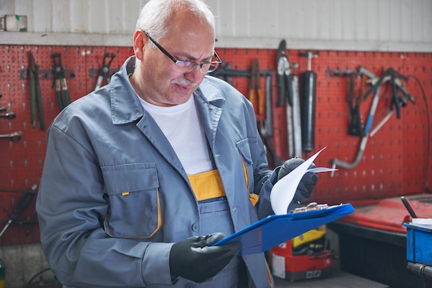 Free photo mechanic checking a car report