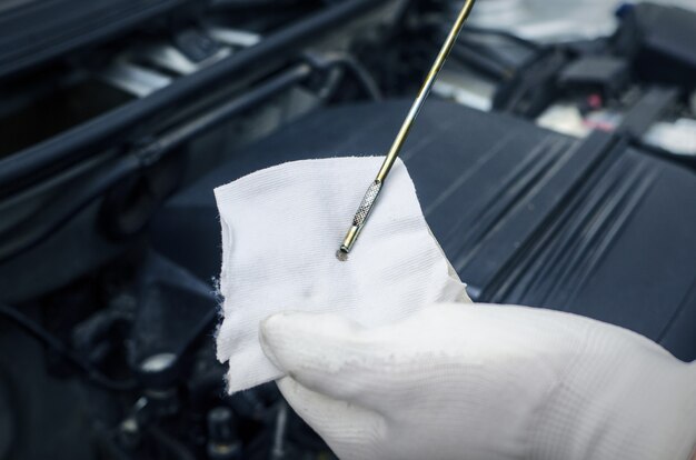 Mechanic checking engine oil level on car vehicle