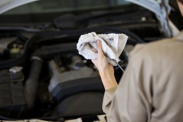 Free photo mechanic checking the oil level in a car engine