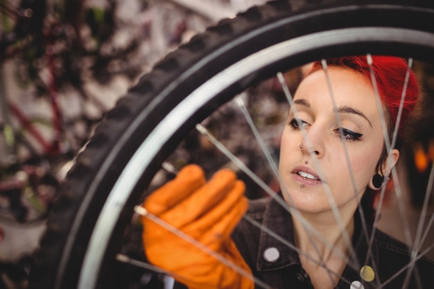 Free photo mechanic examining a bicycle wheel