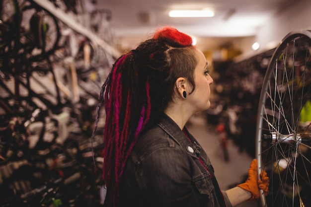 Free photo mechanic examining a bicycle wheel