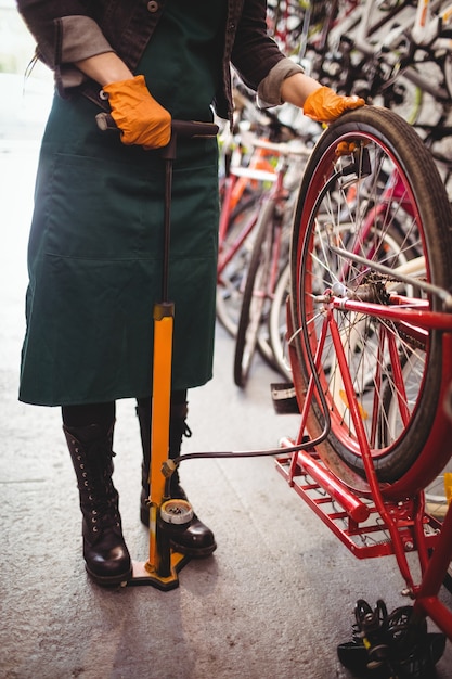 Mechanic filling air into bicycle tire with air pump