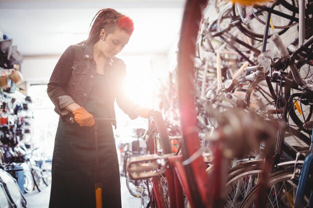 Mechanic filling air into bicycle tire with air pump