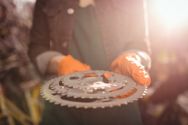 Free photo mechanic holding a bicycle gear