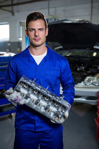 Free photo mechanic holding car engine