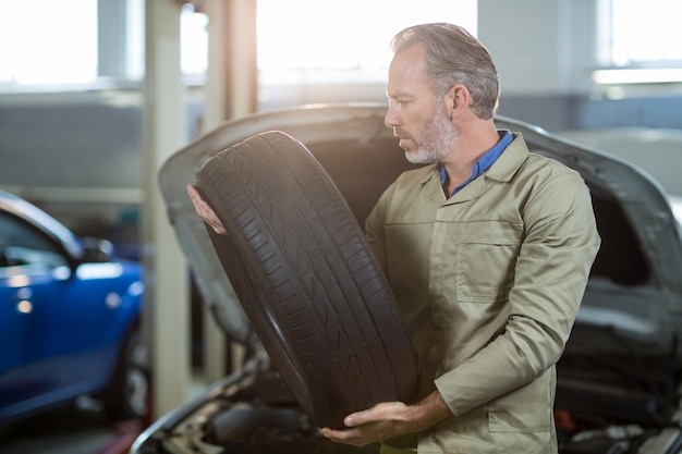 Free photo mechanic holding a tyre