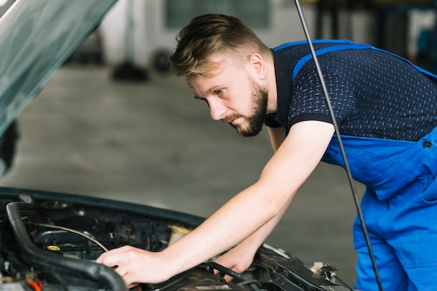 Mechanic repairing car motor