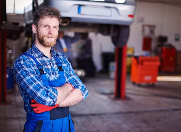 Foto gratuita meccanico che ripara un'auto in officina