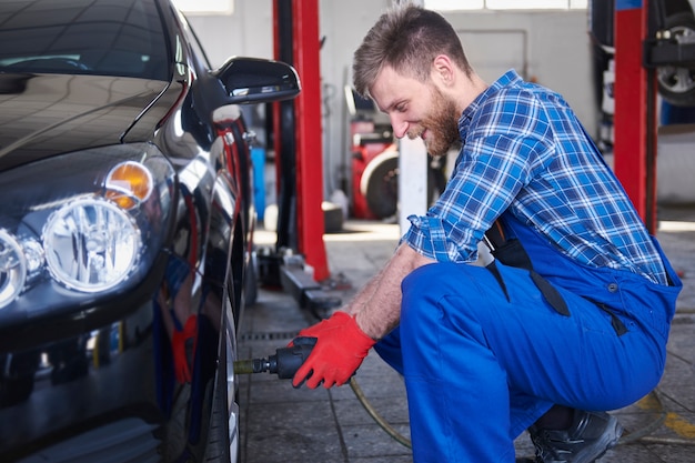 Free photo mechanic repairing a car in the workshop