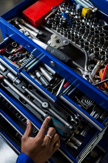 Mechanic selecting work tool from toolbox