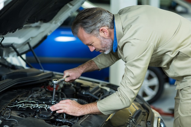 Free photo mechanic servicing a car engine