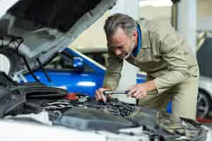 Free photo mechanic servicing a car engine