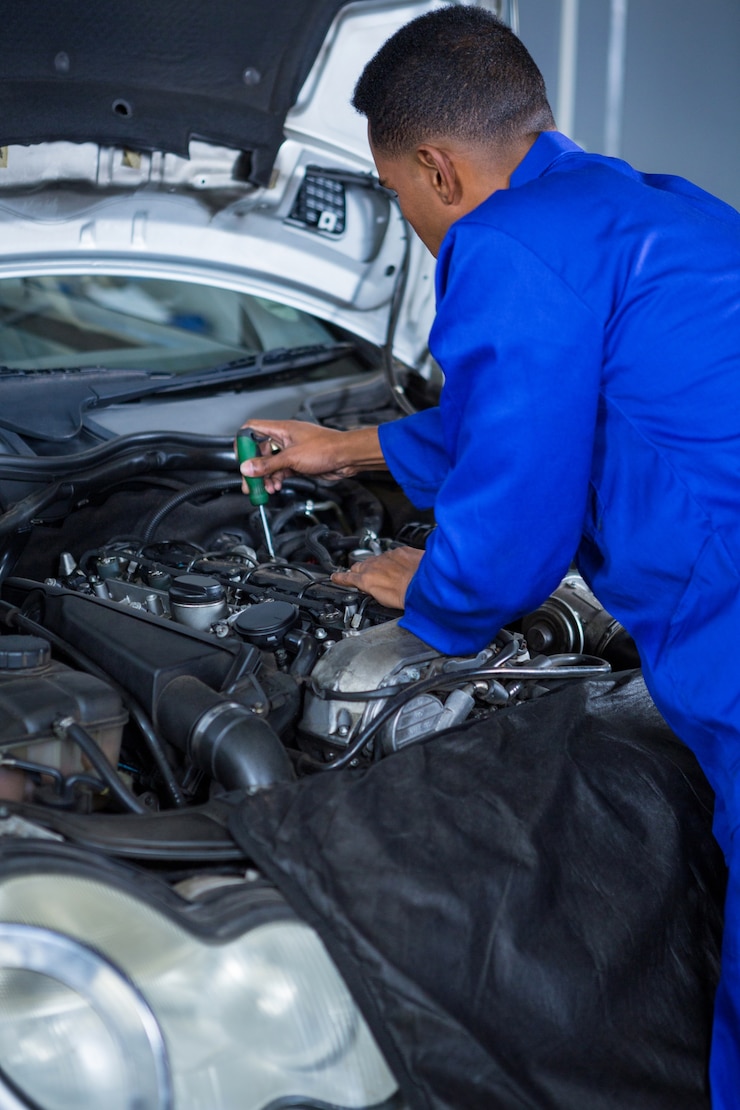 Free Photo mechanic servicing a car engine