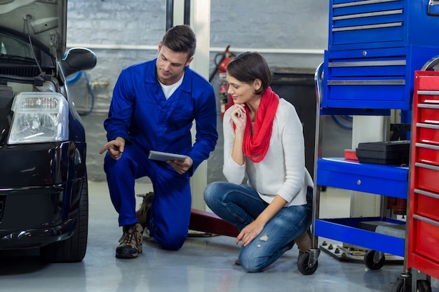 Free photo mechanic showing customer the problem with car