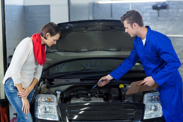 Mechanic showing customer the problem with car