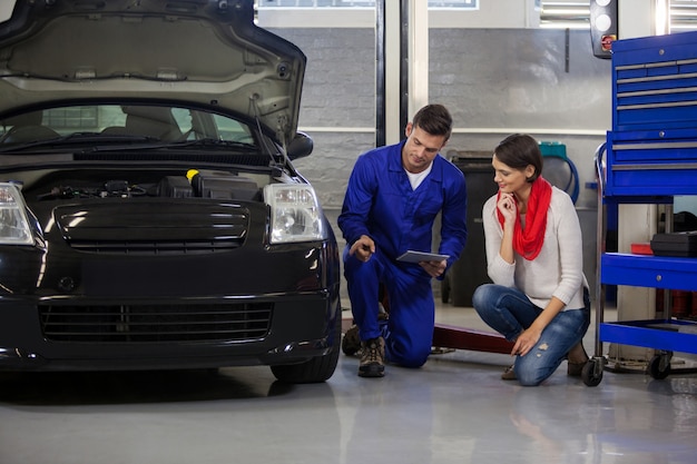 Mechanic showing customer the problem with car