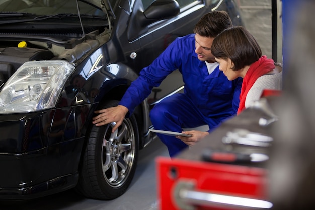 Mechanic showing customer the problem with car