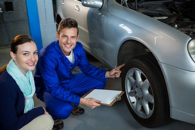 Mechanic showing customer the problem with car