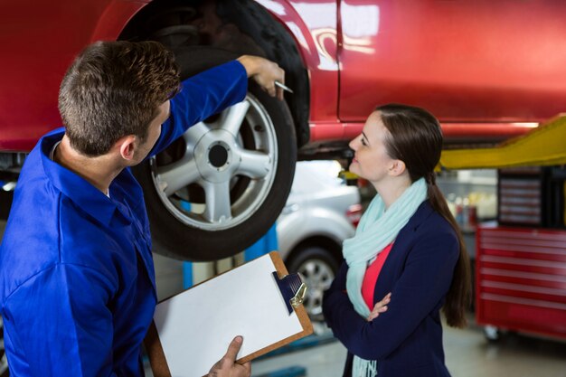 Mechanic showing customer the problem with car