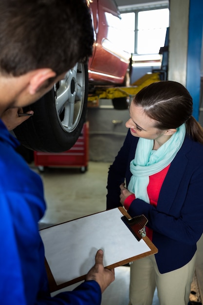 Mechanic showing customer the problem with car