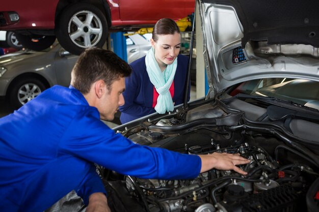 Mechanic showing customer the problem with car