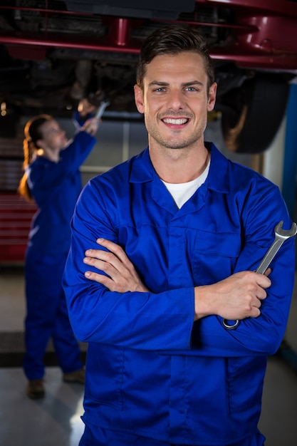 Foto gratuita in piedi meccanico al garage di riparazione