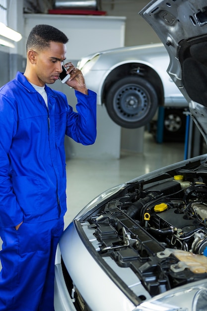 Free photo mechanic talking on a mobile phone