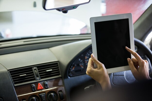 자동차에서 디지털 태블릿을 사용하는 정비공