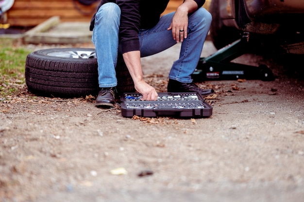 Meccanico con strumenti che riparano un'auto