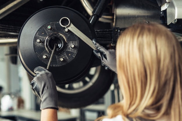 車の車輪を変える機械的な女性