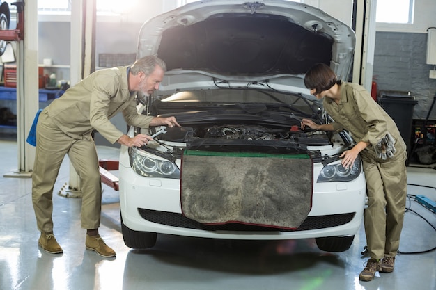 Free photo mechanics examining car engine